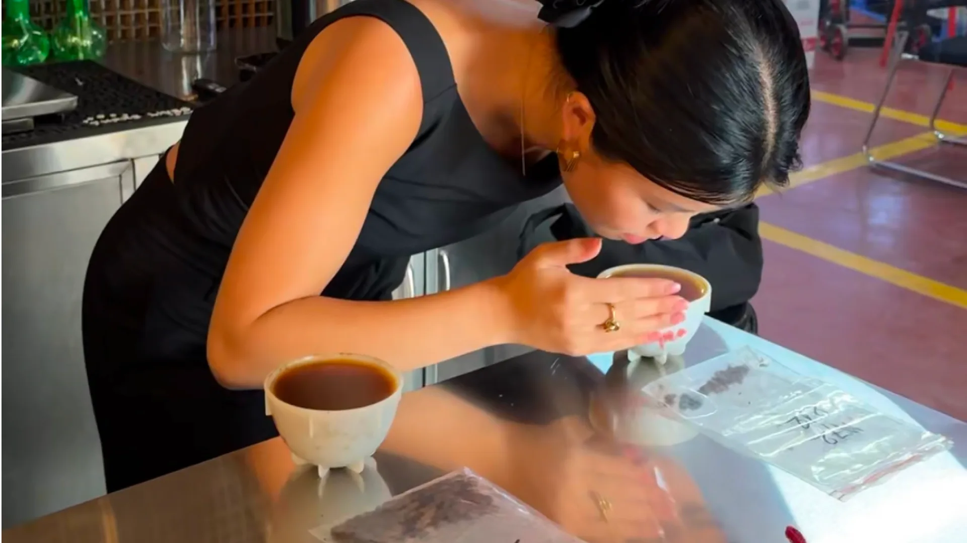 A TRAN Coffee Lab founder tasting Vietnamese coffee from a cupping bowl