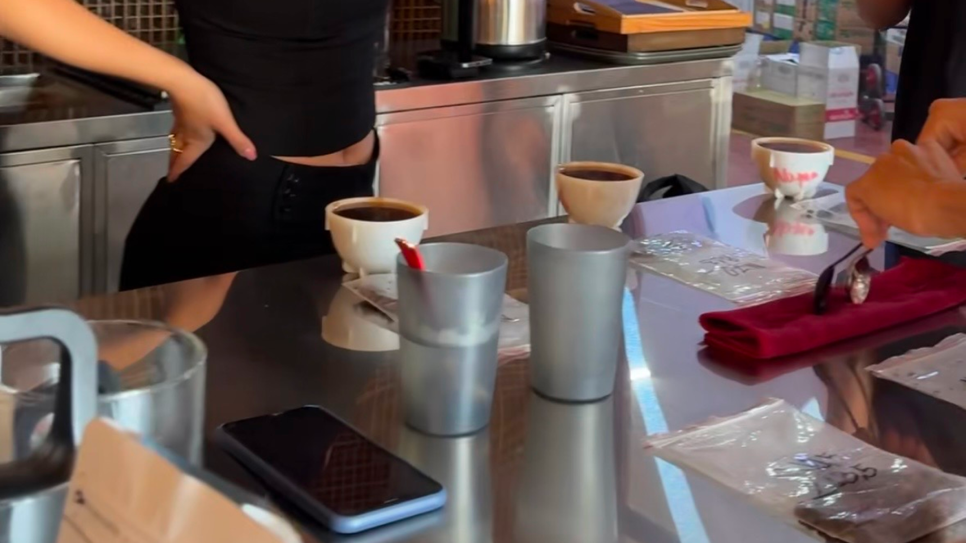 A coffee cupping table set with cups and tasting spoons